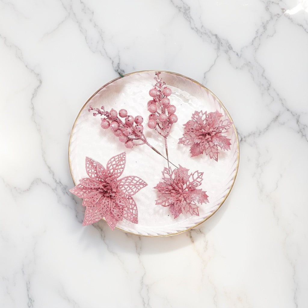 Blush pink glitter poinsettia and berry decorations arranged on marble plate - elegant festive florals for Christmas styling