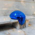 Blue melting disco ball reflecting cool light on a marble surface - modern Christmas décor accent