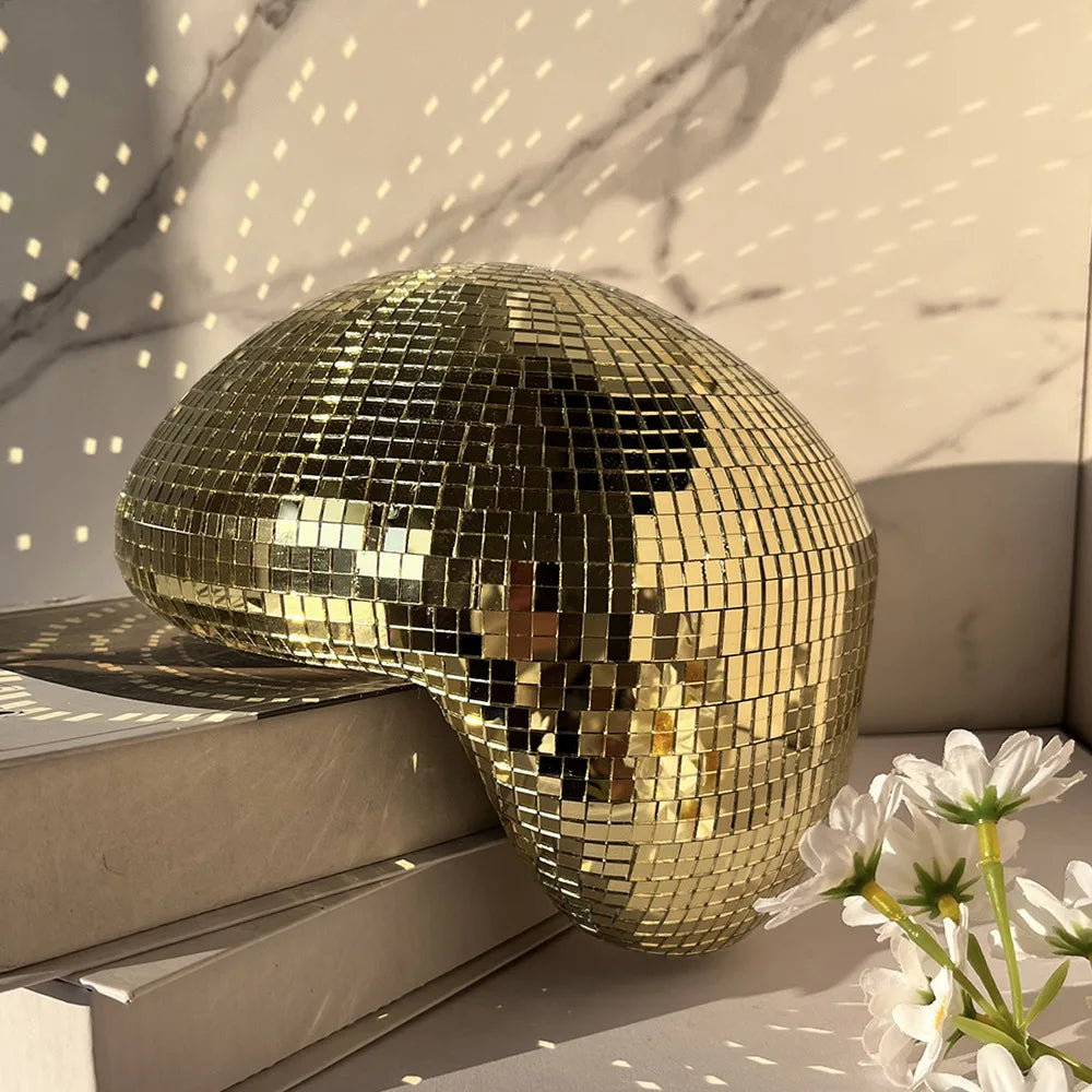 Gold melting disco ball reflecting soft light on a marble backdrop, modern Christmas décor accent.