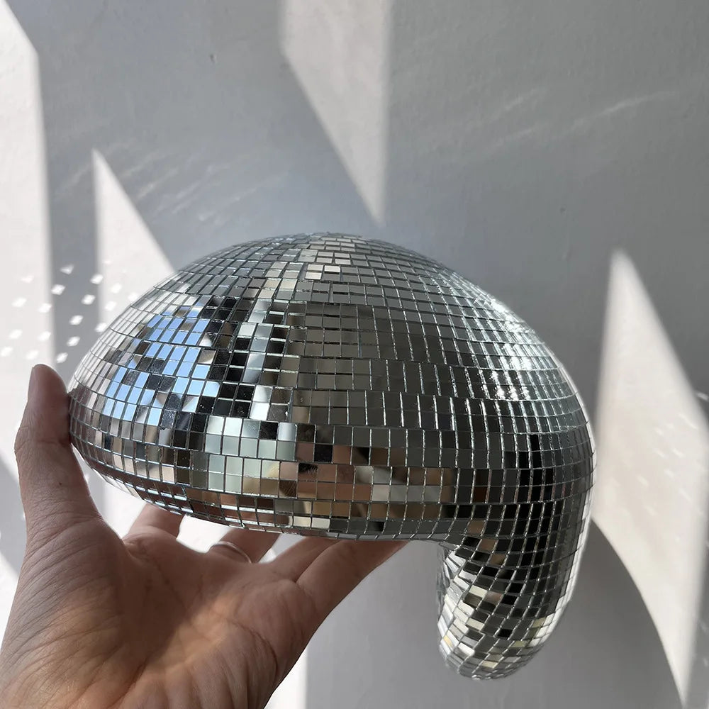 Silver melting disco ball reflecting cool light on a marble surface, modern Christmas décor accent